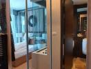 Modern bedroom with reflective sliding door wardrobe leading to an ensuite bathroom