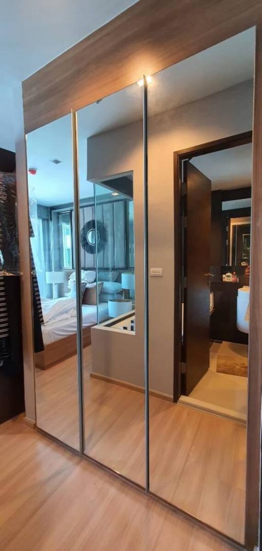Modern bedroom with reflective sliding door wardrobe leading to an ensuite bathroom