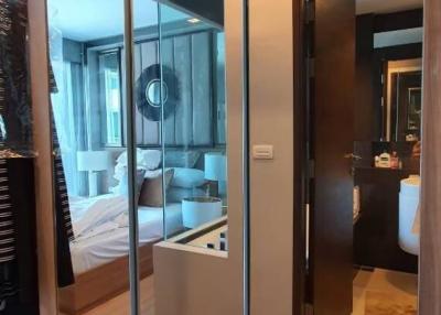 Modern bedroom with reflective sliding door wardrobe leading to an ensuite bathroom