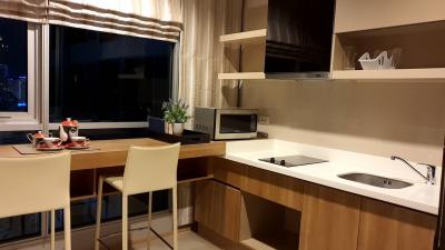 Modern kitchen with dining area and city view at dusk