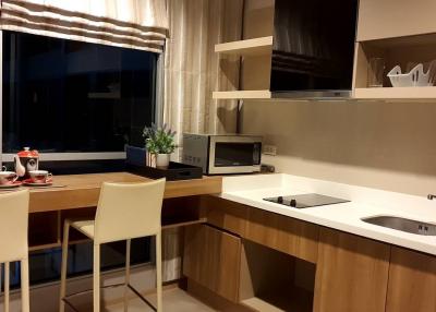 Modern kitchen with dining area and city view at dusk