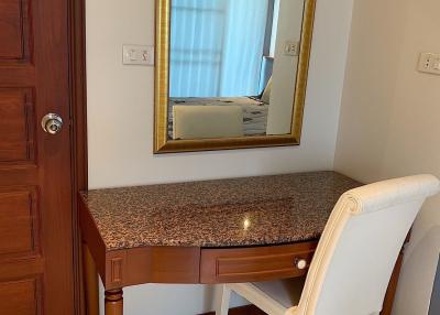 Elegant bedroom corner with a vanity desk and a comfortable chair