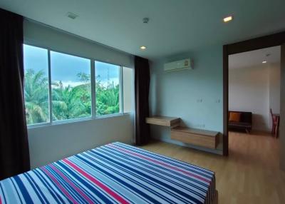 Spacious bedroom with modern design, large window with a view, and ample natural light