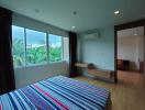 Spacious bedroom with modern design, large window with a view, and ample natural light