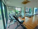 Modern home gym with exercise equipment and large windows