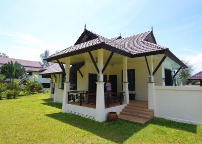 Front view of a spacious single-family home with a lush green lawn