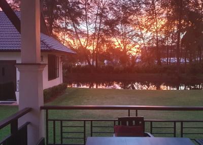 Sunset view from the terrace of a residential home overlooking a tranquil pond