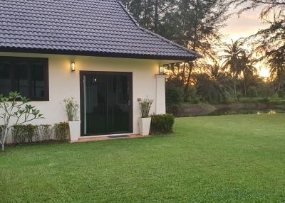 Exterior view of a standalone house at dusk with green lawn