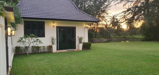 Exterior view of a standalone house at dusk with green lawn