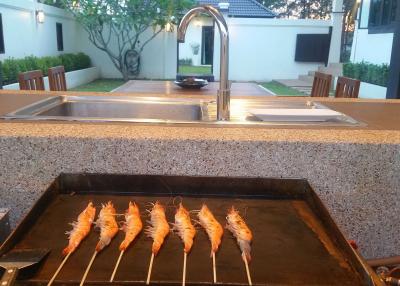 Outdoor kitchen with grill and sink in a residential backyard