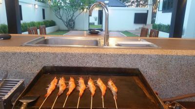 Outdoor kitchen with grill and sink in a residential backyard