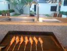 Outdoor kitchen with grill and sink in a residential backyard