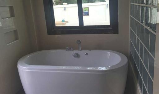 Modern bathroom with a freestanding bathtub and dark tiles