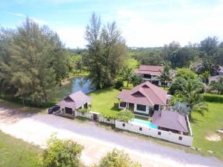 Aerial view of a residential property with multiple buildings surrounded by lush greenery