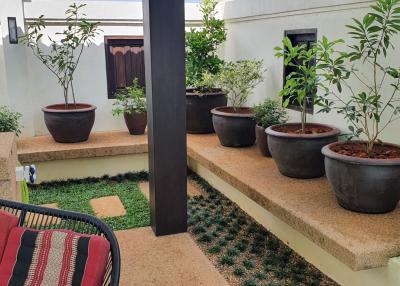 Cozy patio area with potted plants and bench