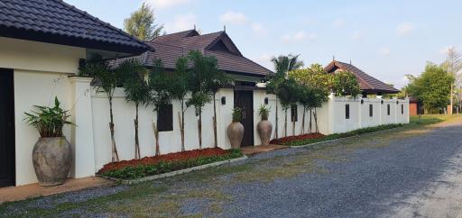 Modern single-story residential building with tropical landscaping