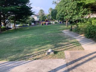 Spacious community garden with playground equipment and green lawn