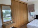 Spacious bedroom with large wooden wardrobe and plenty of natural light