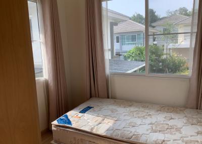 Bright bedroom with large window and suburban view