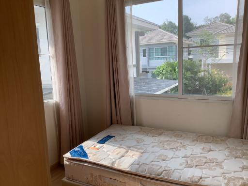 Bright bedroom with large window and suburban view