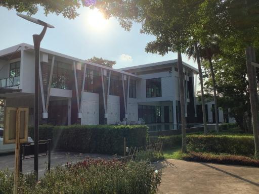 Contemporary two-story building with large windows and lush garden