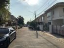 Quiet suburban street with modern houses and parked cars