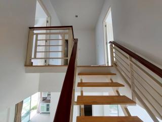 Bright and airy staircase with wooden steps and a view from the upper landing