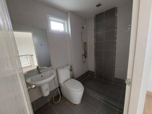 Modern bathroom with wall-mounted sink, toilet, and walk-in shower