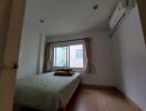 Spacious bedroom with a large window and an air conditioning unit