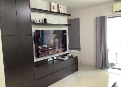 Modern living room interior with large TV screen and ample shelving