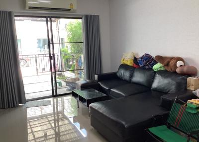 Modern living room with a large comfortable sofa and sliding doors leading to a balcony