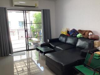 Modern living room with a large comfortable sofa and sliding doors leading to a balcony