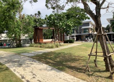 Spacious outdoor area with green lawn, walking path, and gazebo