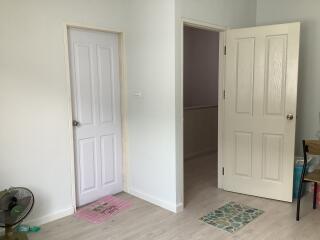 Empty room interior with two closed doors and tiled flooring
