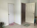 Empty room interior with two closed doors and tiled flooring