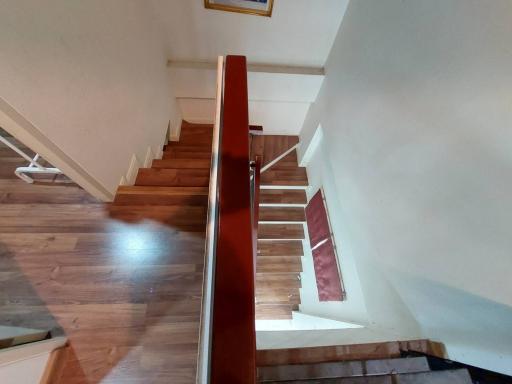 Wooden staircase leading to the upper level of a home with polished hardwood floors
