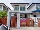 Two-story residential building with a gated entrance