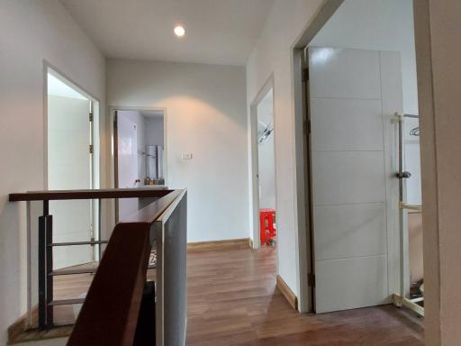 Spacious interior viewpoint showcasing the corridor, wooden flooring, and doors leading to different rooms