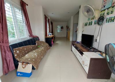 Spacious living room with natural light, furnished with sofa and entertainment unit
