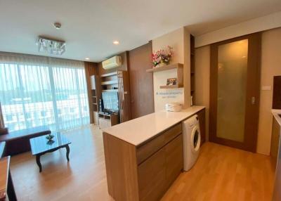 Modern apartment interior view showing open-plan living space with kitchen and living room