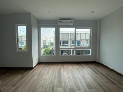 Spacious living room with large windows and air conditioning unit