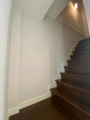 Clean interior staircase with wooden steps and white walls