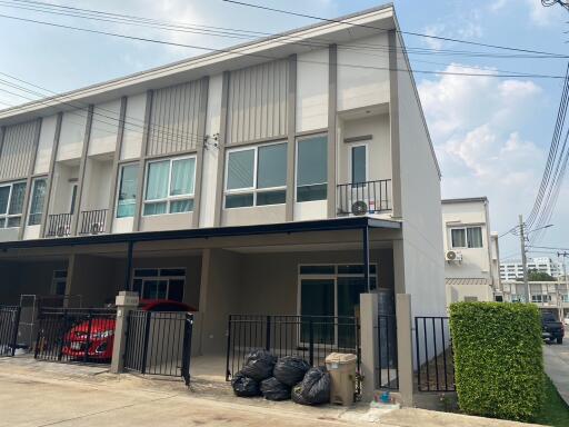 Modern two-story building facade with parking area