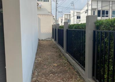 Narrow side yard of a residential property with fencing