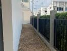 Narrow side yard of a residential property with fencing