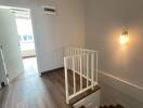 Modern staircase with wooden steps and white railing inside a house