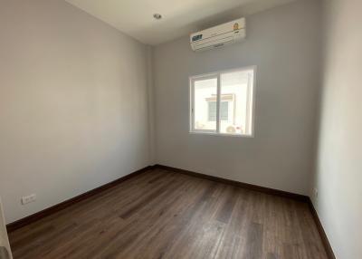 Empty bedroom with wooden flooring and air conditioning unit