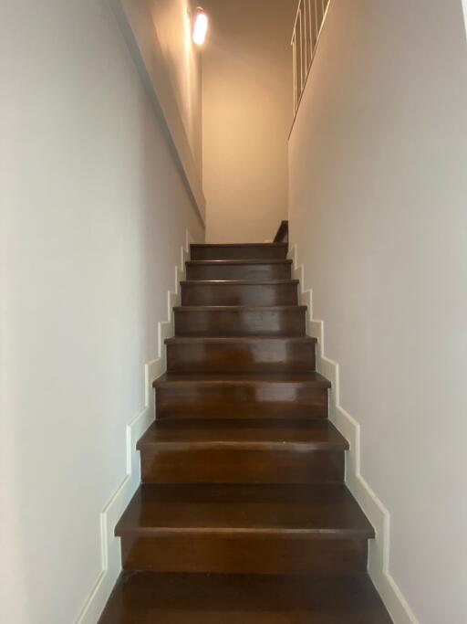 Wooden staircase with white walls leading to the upper level of the home