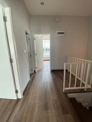 Spacious hallway leading to rooms with wooden flooring and modern design