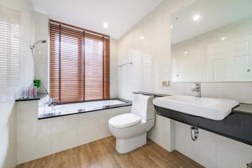 Modern bathroom interior with clean lines featuring a bathtub, toilet, and a large sink